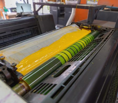 Offset printing machines. Large printing machine perspective. printing machine cylinders and printing ink pot. Offset machine. Offset press is a printing machine designed to produce fine quality